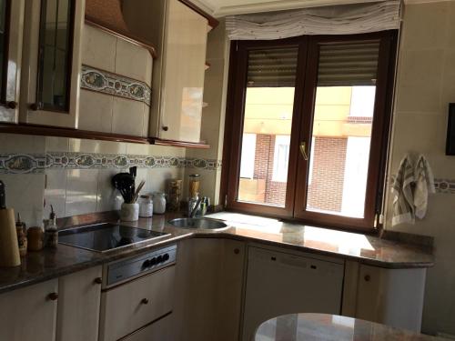 a kitchen with a sink and a window at El mirador in Suances