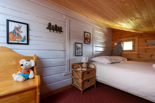 un ours en peluche assis sur une chaise dans une chambre dans l'établissement Chalet Olaf, aux Gets