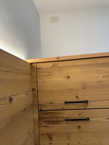 a wooden chest of drawers in a room with a ceiling at Villa la Dama del Lago in Molveno