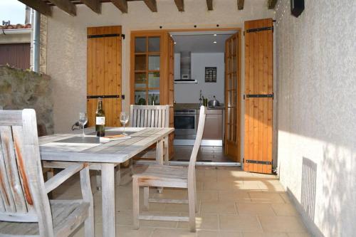 une table et des chaises en bois sur une terrasse avec une cuisine dans l'établissement Luxury cottage with Jacuzzi in Saint-Polycarpe, à Saint-Polycarpe