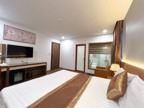 ハノイにあるLuxTel Hotel Tây Hồのベッドとテレビがあるホテルの部屋