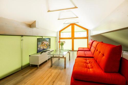 a living room with a red couch and a glass table at AlpinSpa zur Post - Bergbahn im Sommer 2025 inklusive in Bad Gastein