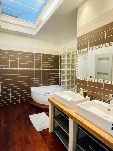 une salle de bain avec deux lavabos et une baignoire dans l'établissement Reims CATHEDRALE JACUZZI LUXURIOUS PROPERTY, à Reims