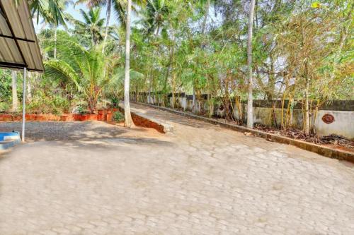 an empty courtyard with palm trees in the background at whispering kera in Pūvār