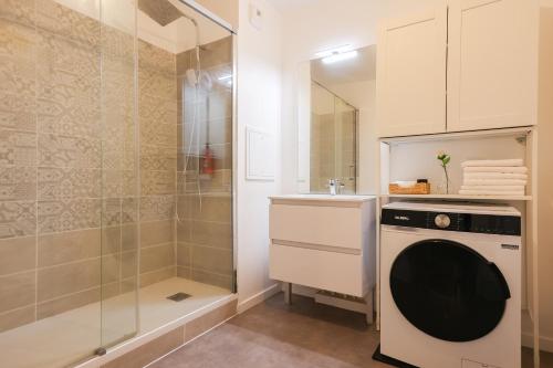 La salle de bains est pourvue d'un lave-linge et d'une douche. dans l'établissement L'appartement Valdargent, à Argenteuil
