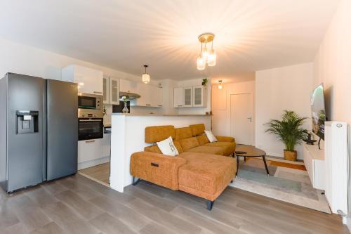 un salon avec un canapé et une cuisine dans l'établissement L'appartement Valdargent, à Argenteuil