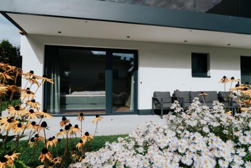 a house with glass doors and flowers in the yard at Apart Praxmarer in Kaunertal
