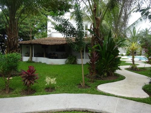 a walkway leading to a house with palm trees at Oasis club in Cap Skirring