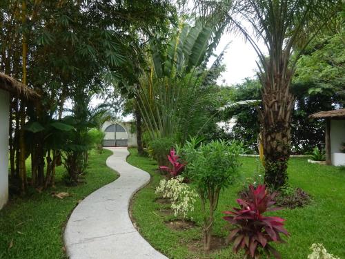 a walkway through a garden with palm trees at Oasis club in Cap Skirring