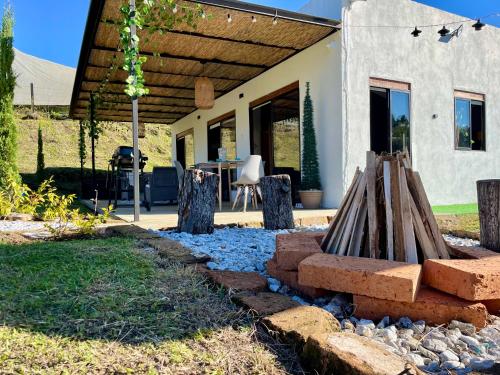 a backyard with a stone fire pit in front of a house at Casa campestre descanso relajación jacuzzi BBQ amplias zonas verdes in Carmen de Viboral