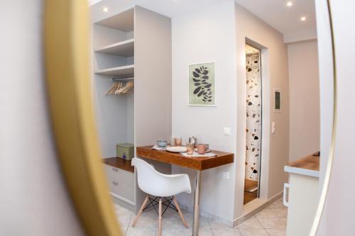 a small kitchen with a table and a white chair at Spyridoula Resort in Corfu in Gouvia