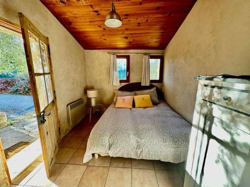 une chambre avec un lit et un plafond en bois dans l'établissement Cute stone cottage in Provence, à Rivest-Saint-Martin