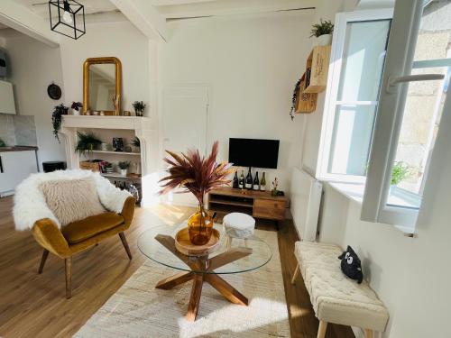 un salon avec une table et une chaise dans l'établissement Le Havre d'Olga - Homillesime, à Dijon