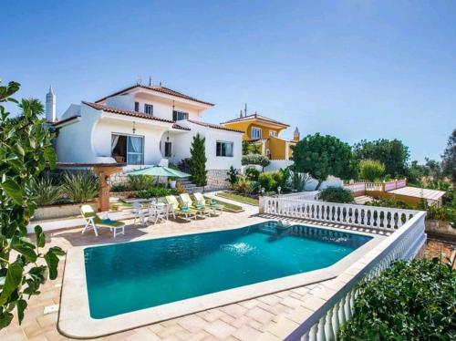 a villa with a swimming pool in front of a house at VILLA SALGADOS, near ALBUFEIRA, with Private Pool, 5 minutes from Gale Beach in Guia