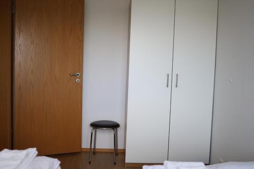 a room with two beds and a stool next to a door at Hekla Adventures in Hvolsvöllur