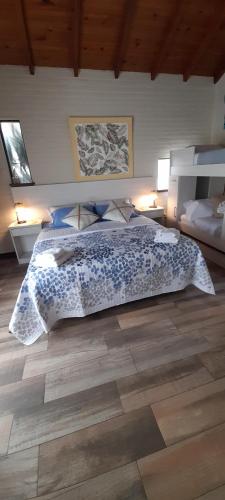 a bedroom with a bed and a wooden floor at Apart Los Cerrillos in Balcarce