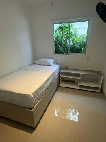 un dormitorio con una cama y una ventana en Apartamentos Cartagena Acuarium, en Cartagena de Indias