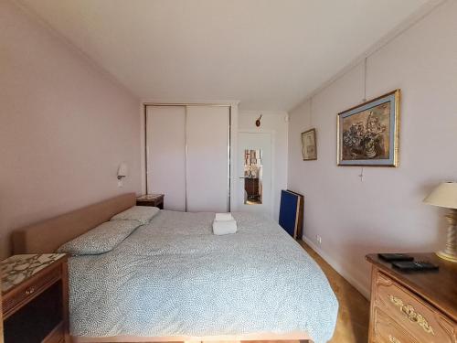 une chambre avec un lit et une commode dans l'établissement Salle - CI - Appartement avec jardin - Paris 6ème, à Paris