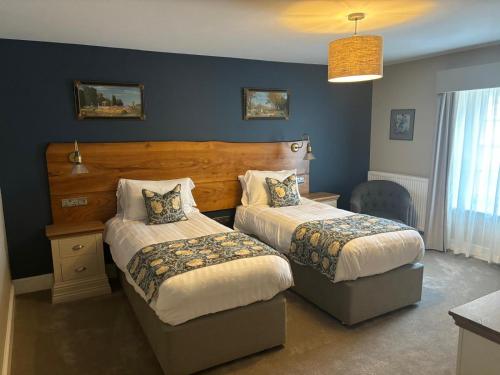 a bedroom with two beds and a blue wall at The Castle Coaching Inn in Trecastle