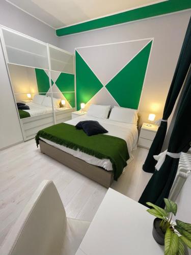 a bedroom with a large bed with a green accent wall at 22CAP apartment in Milan