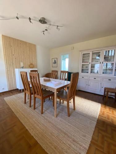 une salle à manger avec une table et des chaises sur un tapis dans l'établissement Maison bord de mer 50 M, à Saint-Georges-de-Didonne