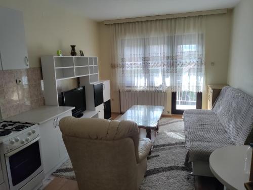 Una sala de estar con un sofá y una mesa y una cocina. en Janković, en Bijeljina