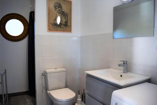 une salle de bain avec des toilettes blanches et un lavabo dans l'établissement Maison NEUVE avec jardin clos à 150m de la mer à Trégastel - Réf 31, à Trégastel