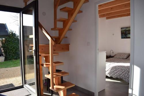 - un escalier en bois dans une chambre avec un lit dans l'établissement Maison NEUVE avec jardin clos à 150m de la mer à Trégastel - Réf 31, à Trégastel