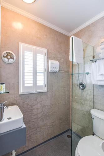 a bathroom with a shower and a toilet and a sink at Chagall's Corner in Key West