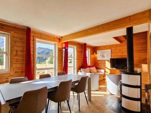 une salle à manger avec une table et une cheminée dans l'établissement Chalet confortable avec poêle et terrasse, 3 chambres, garage, animaux admis - FR-1-425-198, à Arâches-la-Frasse