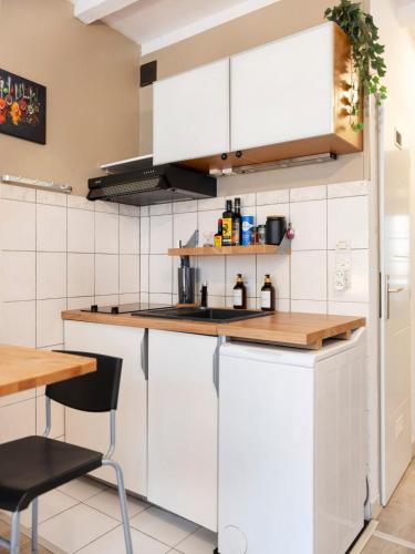 une cuisine avec des armoires blanches et une table dans l'établissement La Petite Evasion, à Metz