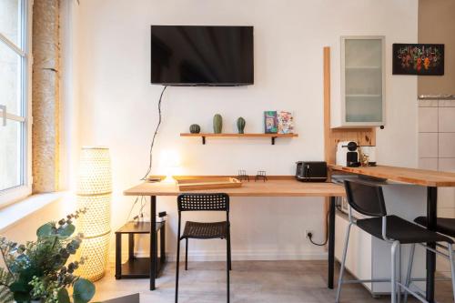 Il comprend une cuisine avec un bureau et une télévision murale. dans l'établissement La Petite Evasion, à Metz