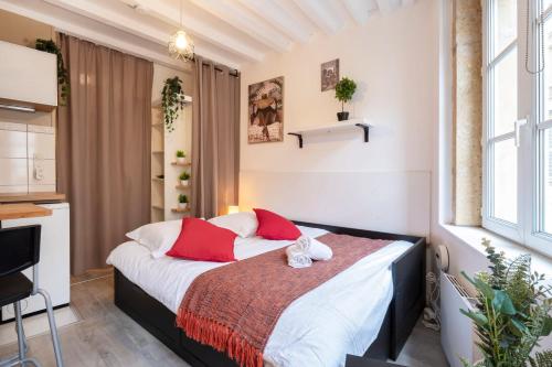 une chambre avec un lit avec des oreillers rouges et blancs dans l'établissement La Petite Evasion, à Metz
