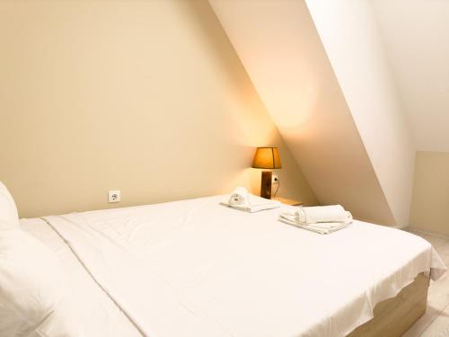 a bedroom with a white bed and a lamp at Elite Business Residence with Free Gym Pass, Street Parking and Full Office Setup in Plovdiv