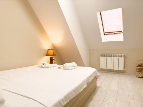 a white bedroom with a bed and a window at Elite Business Residence with Free Gym Pass, Street Parking and Full Office Setup in Plovdiv