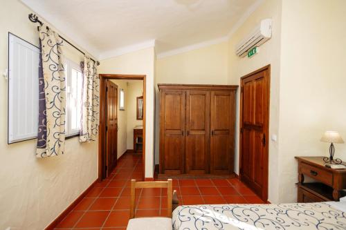 a bedroom with a bed and a wooden door at Herdade Dos Barros in Terena