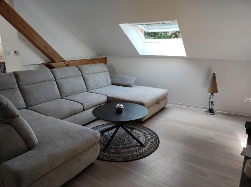una sala de estar con un sofá y una mesa en Gîte Aux murmures de la Streng, en Ribeauvillé