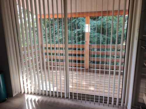 une porte coulissante en verre avec des stores sur une fenêtre dans l'établissement Gîte Aux murmures de la Streng, à Ribeauvillé