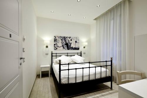 a bedroom with a bed and a table in a room at Affittacamere Arosio in Monza