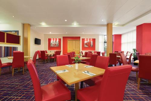 a dining room table with chairs and tables at Ramada London North in Barnet