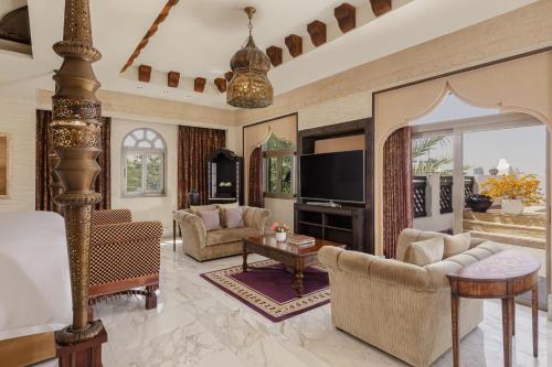 a living room filled with furniture and a flat screen tv at Sharq Village & Spa, a Ritz-Carlton Hotel in Doha