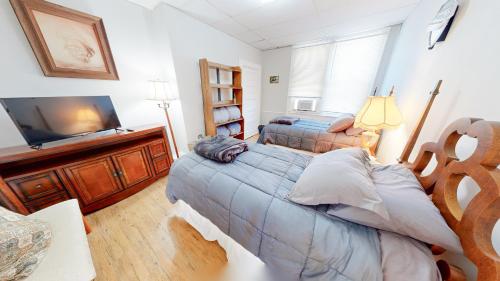 a bedroom with two beds and a flat screen tv at ENTIRE Pittsburgh Home Close To Events - Kid Friendly - Designated Dog & Cat Areas - Private Patio - Free Parking - Fireplace in Pittsburgh