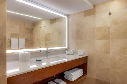 a bathroom with a sink and a large mirror at Hilton Aruba Caribbean Resort & Casino in Palm-Eagle Beach