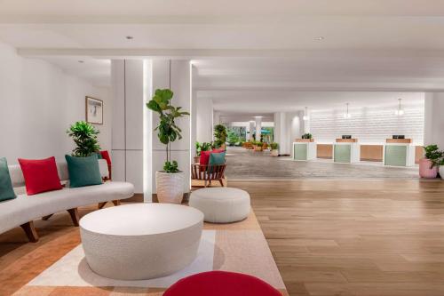 a lobby with couches and tables and potted plants at Hilton Aruba Caribbean Resort & Casino in Palm-Eagle Beach