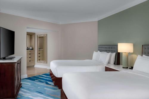 a hotel room with two beds and a flat screen tv at Hilton Aruba Caribbean Resort & Casino in Palm-Eagle Beach