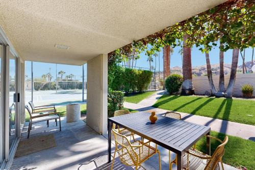 a table and chairs on a patio with a view of a yard at The CoCo Cabana Unit 31 Permit# 4451 in Palm Springs