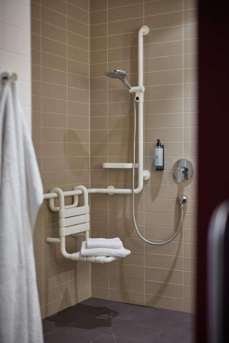 a shower in a bathroom with white towels at bigBOX ALLGAEU Hotel in Kempten