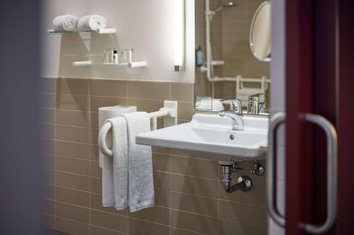 a bathroom with a sink and a mirror at bigBOX ALLGAEU Hotel in Kempten