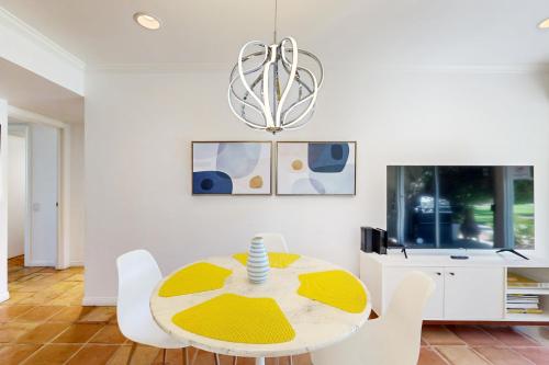 a dining room with a yellow table and white chairs at The CoCo Cabana Unit 31 Permit# 4451 in Palm Springs