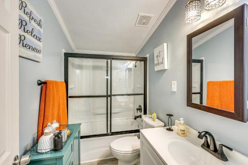 a bathroom with a toilet and a sink and a mirror at Hike, Golf and Fish Pine Bluff Retreat in Pine Bluff
